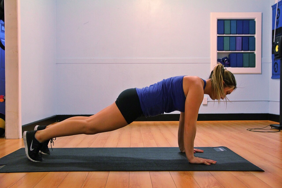 Woman holding a forearm plank on a yoga mat