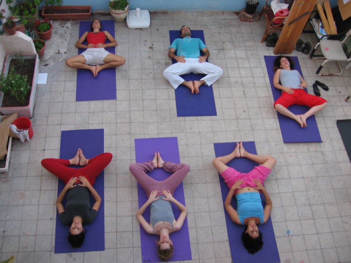 Women lying in Reclined Butterfly Pose during a yoga class